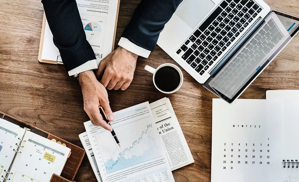 Financial documents, charts and reports being reviewed at a desk
